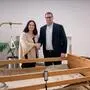 Ein Mann und eine Frau stehen hinter einem Pflegebett und geben sich die Hand | Vizebürgermeister Thomas Leitner und Pflegenahversorgerin Vanessa Pirzl bei der Übergabe eines Pflegebetts