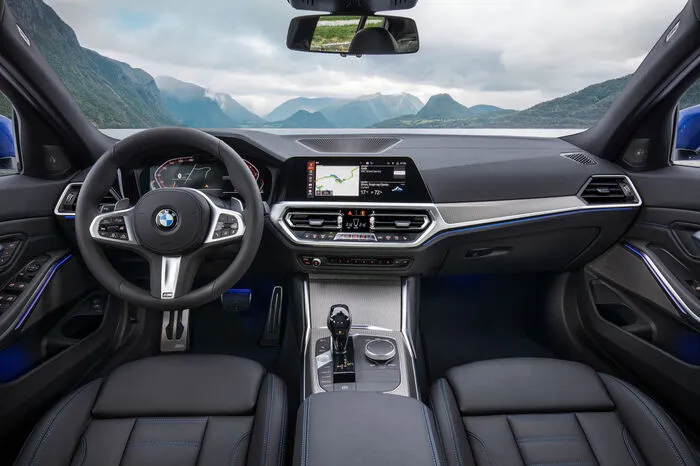 Aufgeräumt haben die Bayern im Cockpit: Die Bedieneinheiten sind auf wenige Funktionsfelder konzentriert. Im Zentrum der Instrumententafel bilden die Anzeigen und Bedientasten der Klimaanlage und die Luftausströmer eine Einheit. Zur Aktivierung der Lichtfunktionen dient ein Tastenfeld neben dem serienmäßigen Lederlenkrad. Der Start-/Stopp-Knopf ist nun im neugestalteten Bedienfeld auf der Mittelkonsole angeordnet, wo sich neben dem Schalthebel beziehungsweise Gangwahlschalter auch der Infotainment-Controller, die Tasten für die verschiedenen Fahrmodi und elektromechanische Parkbremse befinden.