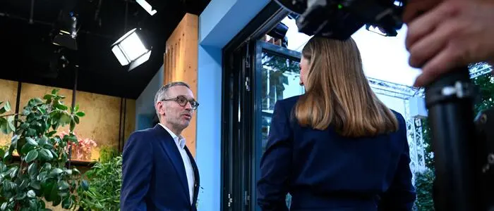 FPÖ-Bundesparteiobmann Herbert Kickl und Moderatorin Simone Stribl stehen in einer Tür. Auf sie ist eine Kamera gerichtet.