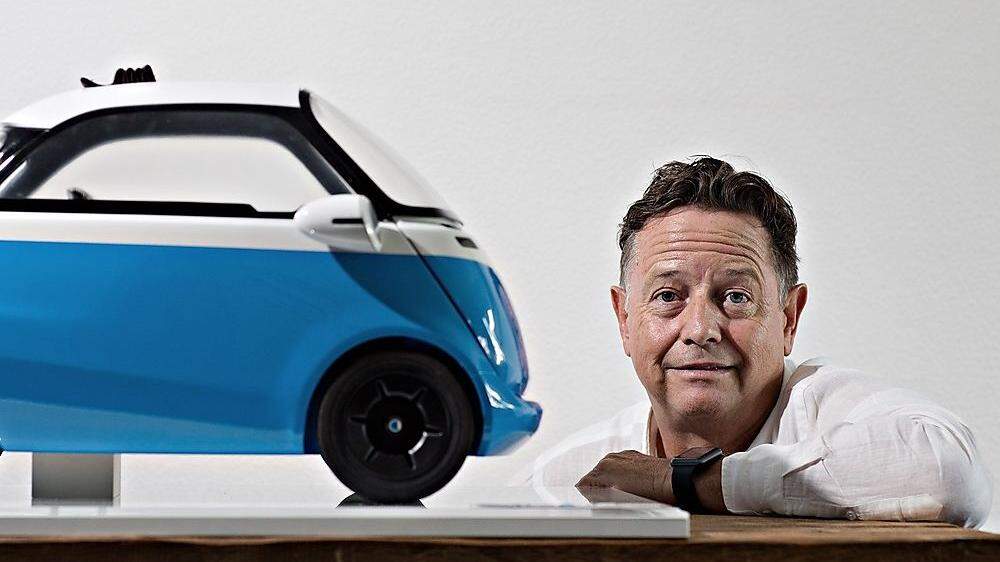 Wim Ouboter und ein Modell seines Elektromobils Microlino