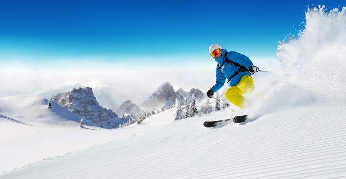 Skier on piste running downhill