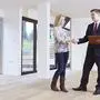 Woman Shaking Hands With Estate Agent In New Home