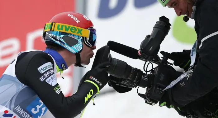 Finland's Janne Ahonen kisses into a TV camera after his final jump at the third stage of the four hills ski jumping tournament in Innsbruck, Austria, Saturday, Jan. 4, 2014. (AP Photo/Matthias Schrader)