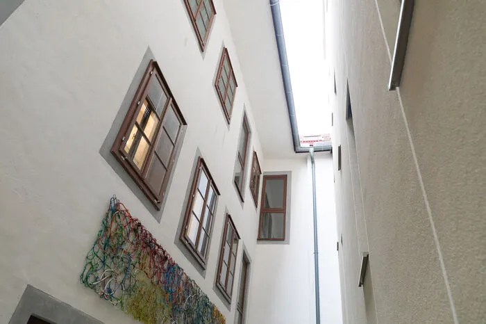 Die Idee des ursprünglichen Laubengangs wurde wieder aufgenommen - er trennt den Altbau vom Neubau. Den Komplex aus 23 Wohnungen betritt man durch nur eine Tür.