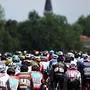 The pack of riders cycles during the 13th stage of the 110th edition of the Tour de France cycling race, 138 km between Chatillon-sur-Chalaronne in central-eastern France and Grand Colombier, in the Jura mountains, in France, on July 14, 2023. (Photo by Anne-Christine POUJOULAT / AFP)