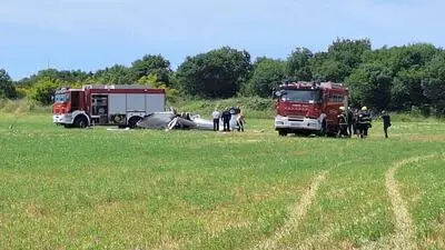 Man sieht zwei Feuerwehrwagen bei einem abgestürzten Flugzeug stehen