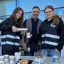 Drei Leute schenken Kaffee aus