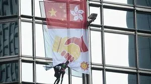 Robert entrollte ein Banner, das die Flaggen Chinas und Hongkongs sowie zwei sich schüttelnde Hände zeigt
