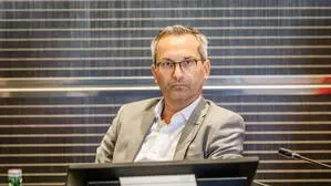 Mann in grauem Anzug und mit Brille blickt grimmig in die Kamera