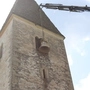 In einen Kirchturm wird eine Glocke gehoben