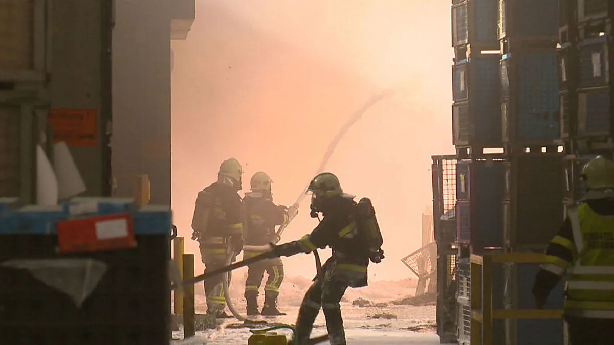 Unter schwerem Atemschutz versuchen Feuerwehrleute den Brand zu löschen