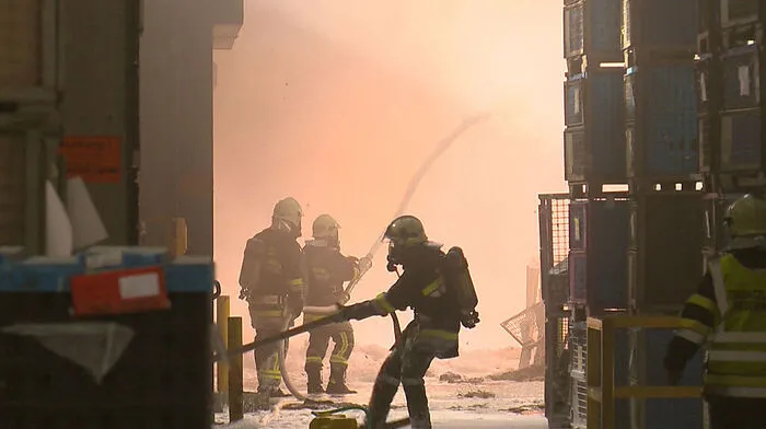 Unter schwerem Atemschutz versuchen Feuerwehrleute den Brand zu löschen
