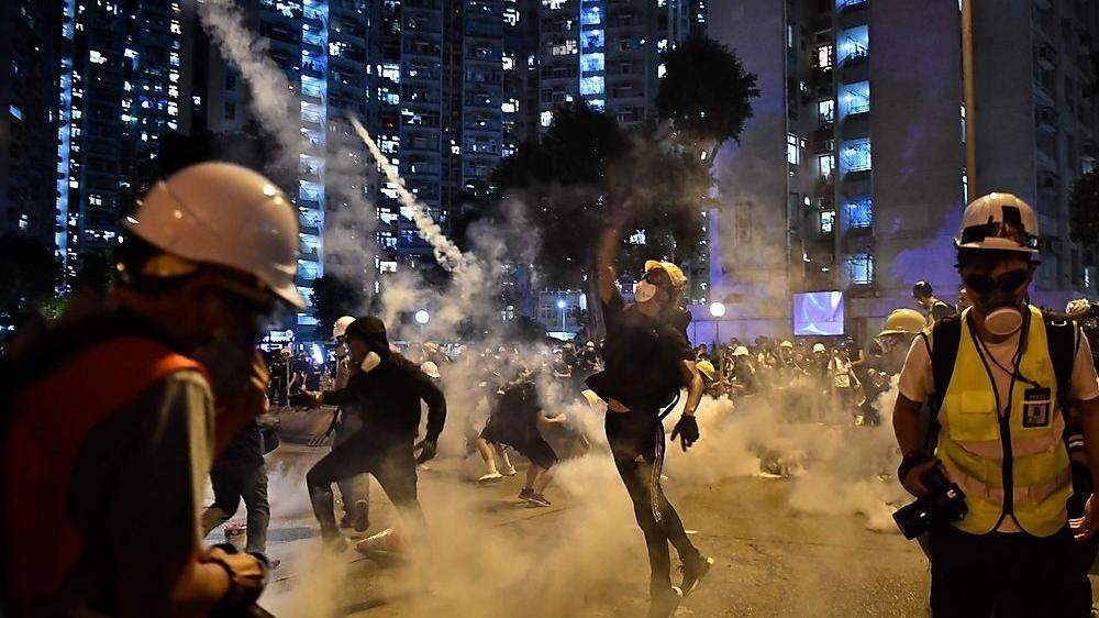 Protestierende werfen der Polizei Tränengas zurück