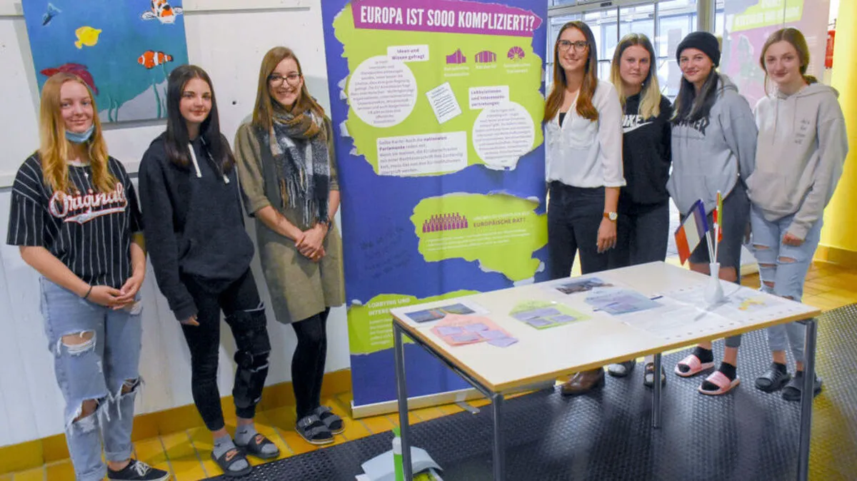 Sophia Müller aus der 3AHW (links neben dem Aufsteller) und Lehrerin Theresa Dollenz (rechts vom Aufsteller) wurden bei der Wanderausstellung von Schülerinnen der 1AMW besucht