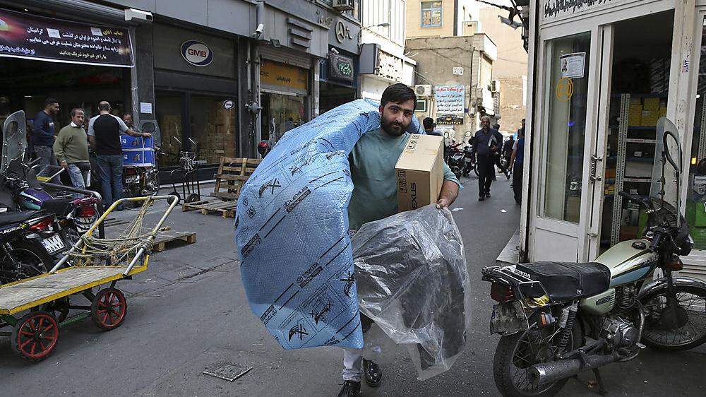 Ein Mann ergatterte Autoteile und schleppt sie über den Markt in Teheran: Die Sanktionen haben viele Güter  zur Mangelware werden lassen, die vorübergehende Aufhebung ließ Hoffnung aufkeimen