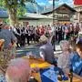 Viele Leute singen, andere hören zu auf dem Dorfplatz in Mallnitz
