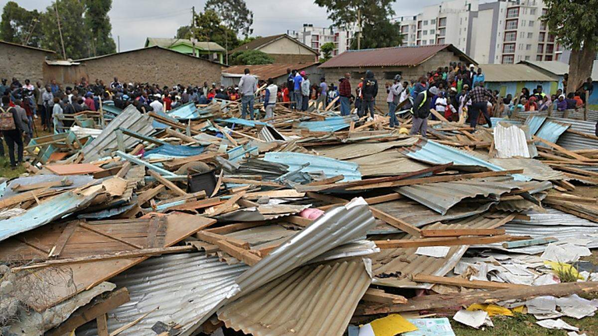 Menschen stehen vor einer kollabierten Schule in Nairobi, Kenia. (Symbolfoto)