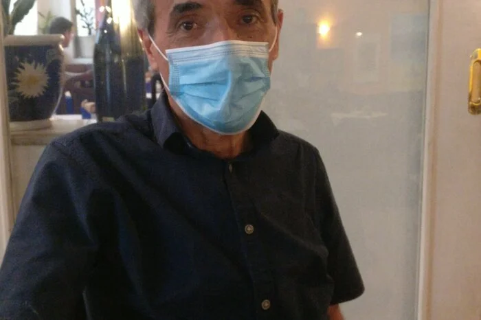Panagiotis Rousakakis, Restaurant "Athen", Graz:Für mich ist die Maske eine Gewohnheitssache. Am Anfang habe ich mir schon gedacht: Mein Gott, jetzt ging das jahrelang ohne Maske und jetzt auf einmal alles nur noch mit? Sicher war die Umstellung am Anfang schwer, aber wir tragen die Masken ja zum Schutz der Leute. Mit der Zeit habe ich mich ans Tragen gewöhnt. Die Welt geht deswegen nicht unter. Ich bin seit 28 Jahren hier im Lokal, ich bin der Chef, kaufe ein, bediene aber auch. Ich trage die Maske etwa acht Stunden pro Tag, aber mit Pause. Manchmal läuft meine Brille halt an. Die Zeiten sind nicht leicht, aber das wird wieder. Ich bin froh, dass wir arbeiten können , es wird wieder bergauf gehen, da bin ich mir sicher. Jammern hilft nicht.