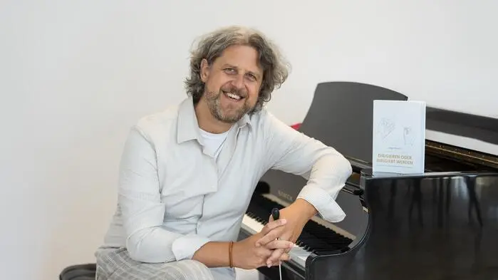  Dirigent Gregor Kovačič in seinem eigenen kleinen Konzertsaal mit Klavier, den er sich in Loibach eingerichtet hat