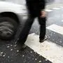 Man on pedestrian crossing in autumn, in danger of being hit by car