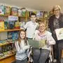 Zwei ältere Damen mit zwei Kindern in einer Bibliothek