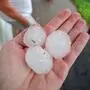 Golfballgroße Hagelkörner in einer Hand