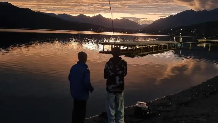 Zwei Angler am See bei Sonnenuntergang