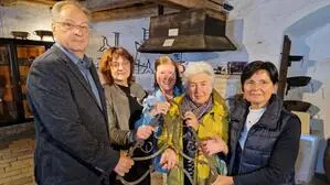 Die neuen Obleute Alois Puntigam (l.) und Andrea Haas (r.) mit Antonia Nitsch (2.v.r.) Gerlinde Jurecek (2.v.l.) und Petra Stessl (3.v.l.) halten das Feuereisen im Feldbacher Tabor, das das Motiv für das neue Vereinslogo bildet