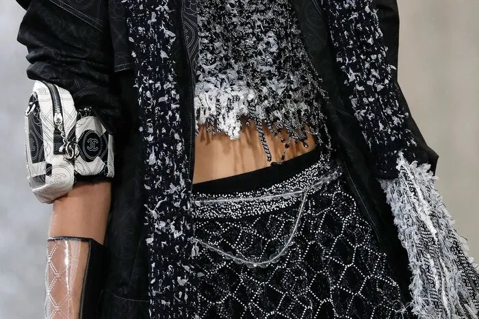 Unter den Mänteln waren die klassischen Chanel-Tweeds zu bauchfreien Bustiers oder kurzen Shorts geschnitten und mit frechen Fransen verziert.