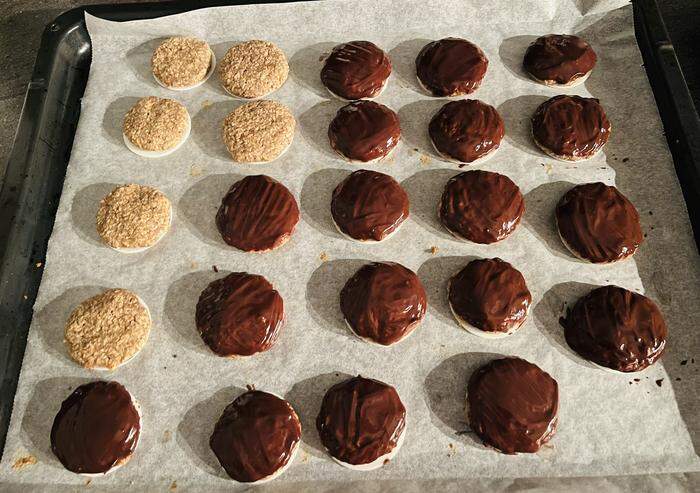 Die fertigen und ausgekühlten Lebkuchen mit der Schokoladeglasur überziehen - wer sie mit Schokolade mag. Sonst einfach weglassen