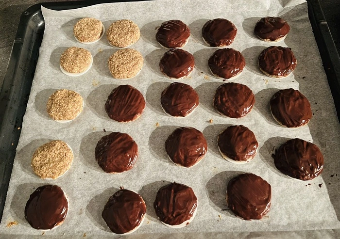 Die fertigen und ausgekühlten Lebkuchen mit der Schokoladeglasur überziehen - wer sie mit Schokolade mag. Sonst einfach weglassen