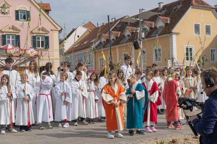 Denn während der Palmweihe am Hartberger Hauptplatz wurde das Kirchenkreuz live mit einem Kran in schwindelerregender Höhe wieder am Kirchenturm befestigt.