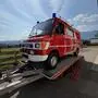 Ein Feuerwehrauto steht auf einem Anhänger