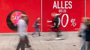 Passanten vor Schaufenster mit 50-Prozent-Rabattwerbung 05.08.25, Frankfurt: Symbolfoto, Illustrationsbild, Symbolbild, Illustrationsfoto, Alltagsszene Mehrere unscharf vorbeigehende Passanten und ein Radfahrer bewegen sich an einem Schaufenster mit auffälliger roter Rabattwerbung in Frankfurt am Main vorbei. Die Aufschrift Alles bis zu -50 % und Bis zu 50 % reduziert dominiert die Bildfläche und verweist auf einen Schlussverkauf. Die Bewegungsunschärfe verleiht der Szene Dynamik. Frankfurt Hessen Deutschland *** Passers-by in front of shop window with 50 percent discount advertising 05 08 25, Frankfurt Symbol photo, illustration image, symbol image, illustration photo, everyday scene Several blurred passers-by and a cycli Copyright: xThorstenxWagnerx