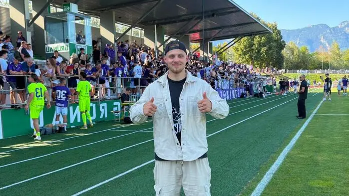 Ein Mann vor einem Spielfeld mit beiden Daumen nach oben