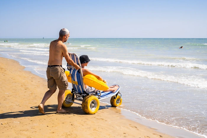 Dank Hilfsmitteln für das Baden, barrierefreien Strandplätzen und inklusiven Tretbooten muss in Bibione niemand auf das Erlebnis Strand verzichten