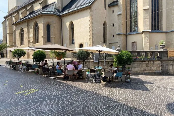 Caffé Latte Bar Direkt vor der Stadtkirche prägt der Gastgarten der Caffé Latte Bar in der 10.-Oktober-Straße 2 das Stadtbild. Ob am Vormittag für einen Kaffee oder am frühen Abend für ein Feierabendgetränk bietet der Gastgarten ein kleine aber feine Auswahl an Einkehrmöglichkeiten.