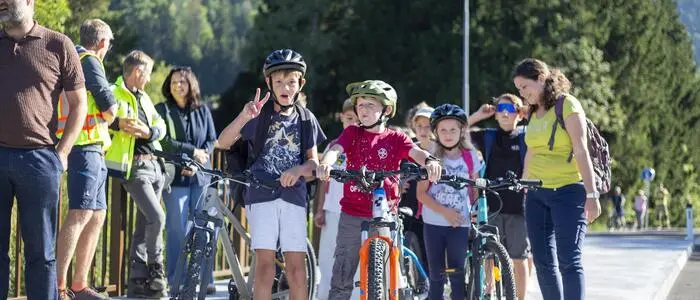 Kinder mit ihren Fahrrädern stehen auf dem verbreiterten Rad- und Fußweg der Debantbachbrücke