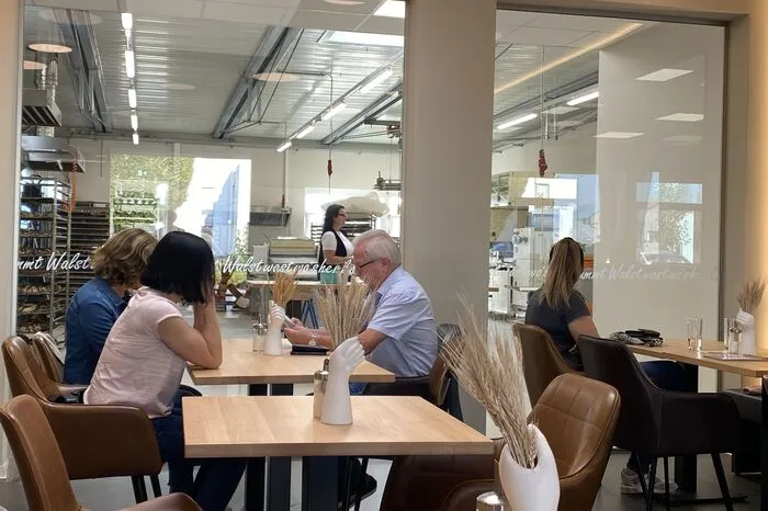 Interessiert schauen einige Gäste zu, wie die Köstlichkeiten in der Bäckerei hergestellt werden
