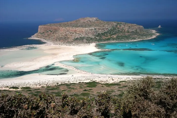Balos Bucht, Kreta.Dieser Traumstrand liegt im Westen Kretas, nahe des Ortes Kissamos. Der Muschel- und Korallensand ist weiß, sehr fein und glitzert in der Sonne. Das Wasser schillert in Blau- und Grüntönen. In Kombination mit der vorgelagerten Insel Gramvousa und ihrer venezianischen Burg wirkt diese Gegend wie eine Traumlandschaft.
