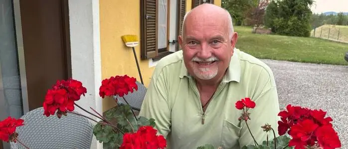 Zu sehen ist ein Mann, der in die Kamera lacht 