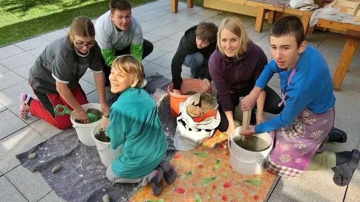 Praktikantin Anna Schett umringt von jungen, fleißigen Handwerkern
