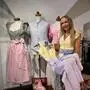 Eine junge Frau in pastellfarbenen Dirndl lächelt in die Kamera