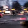 A cyclist drives at twilight over a road intersection 

