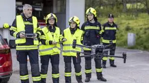 Vier Menschen in einer Reihe aufgestellt, vor ihnen hebt eine Drohne ab