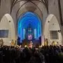 Der Innenraum einer Kirche, das Publikum blickt auf die Bühne mit dem Künstler