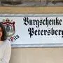Ein Mann und eine Frau stehen vor einem Lokal und lächeln in die Kamera.