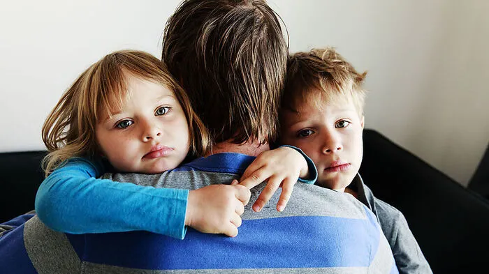 sad little boy and girl hugging father, family in sorrow