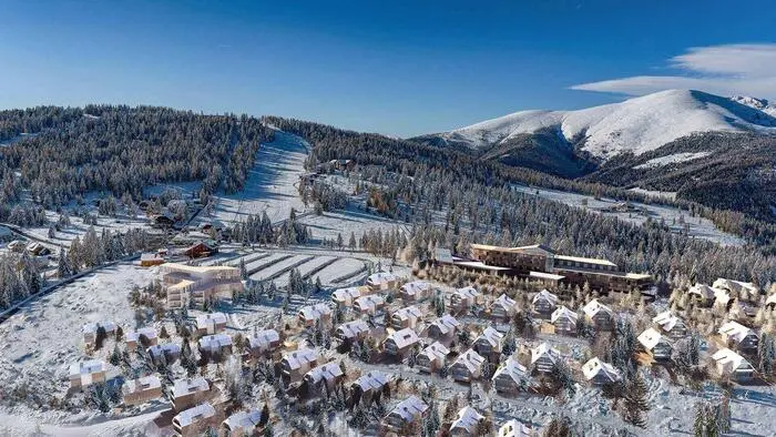 Ein Chaletdorf inmitten einer verschneiten Winterlandschaft.