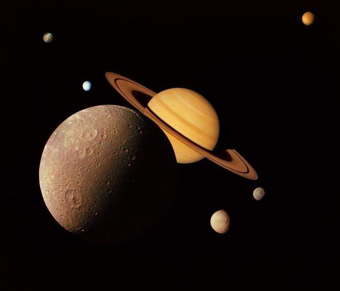 Eine Collage von Aufnahmen, die "Voyager 1" 1980 vom Saturn und seinen Monden Dione, Tethys, Enceladus and Rhea lieferte